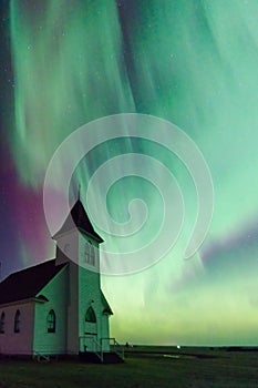 Heart-shaped northern lights over church in Saskatchewan, Canada photo